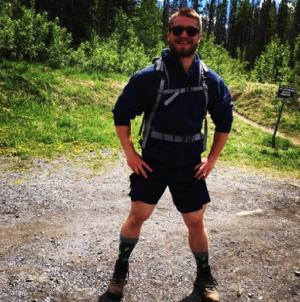 man standing on forest path