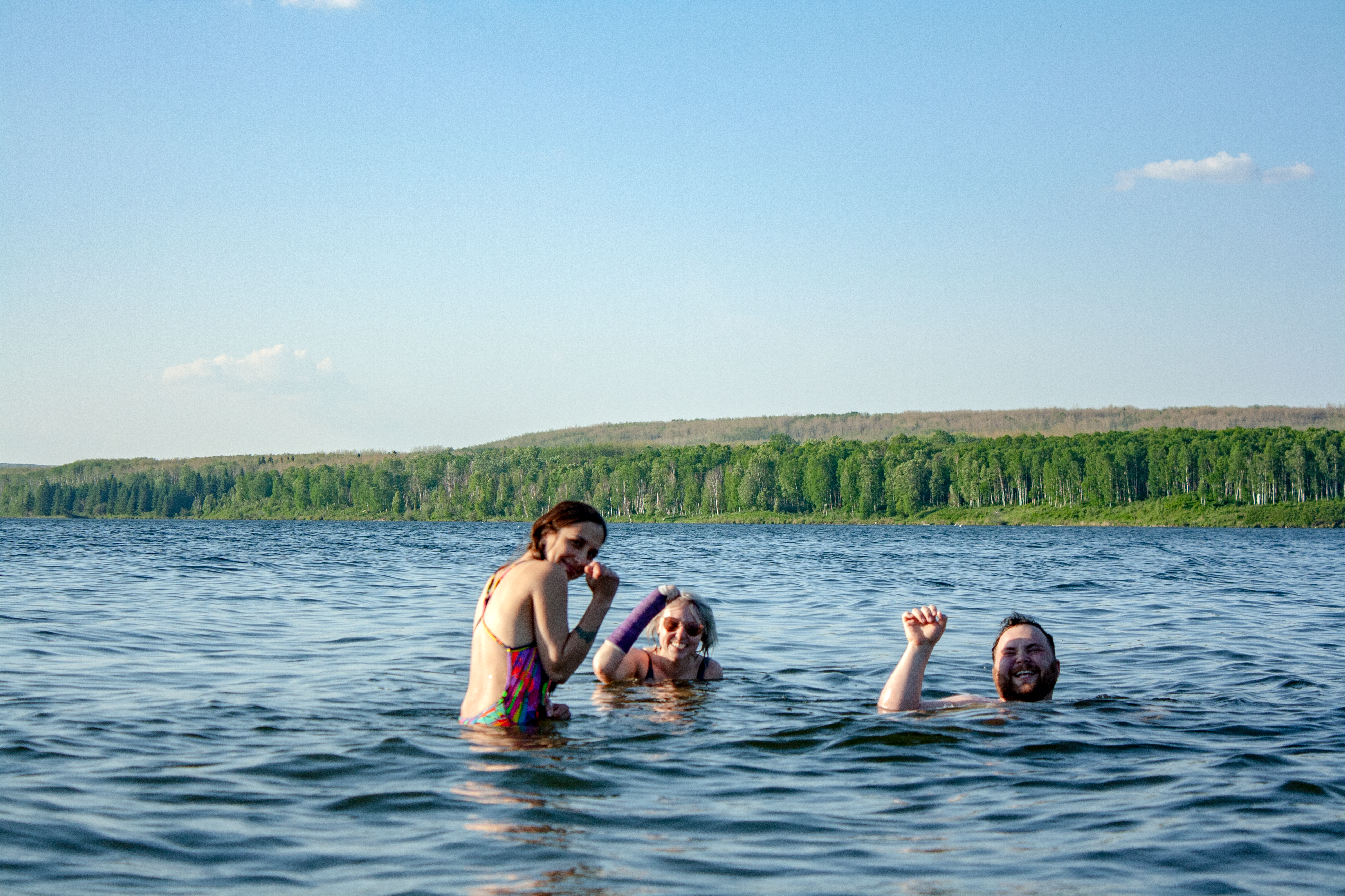 three friends swimming in lake