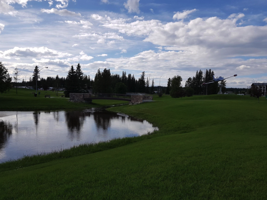 view of field with lake and vibrant cloudy sky