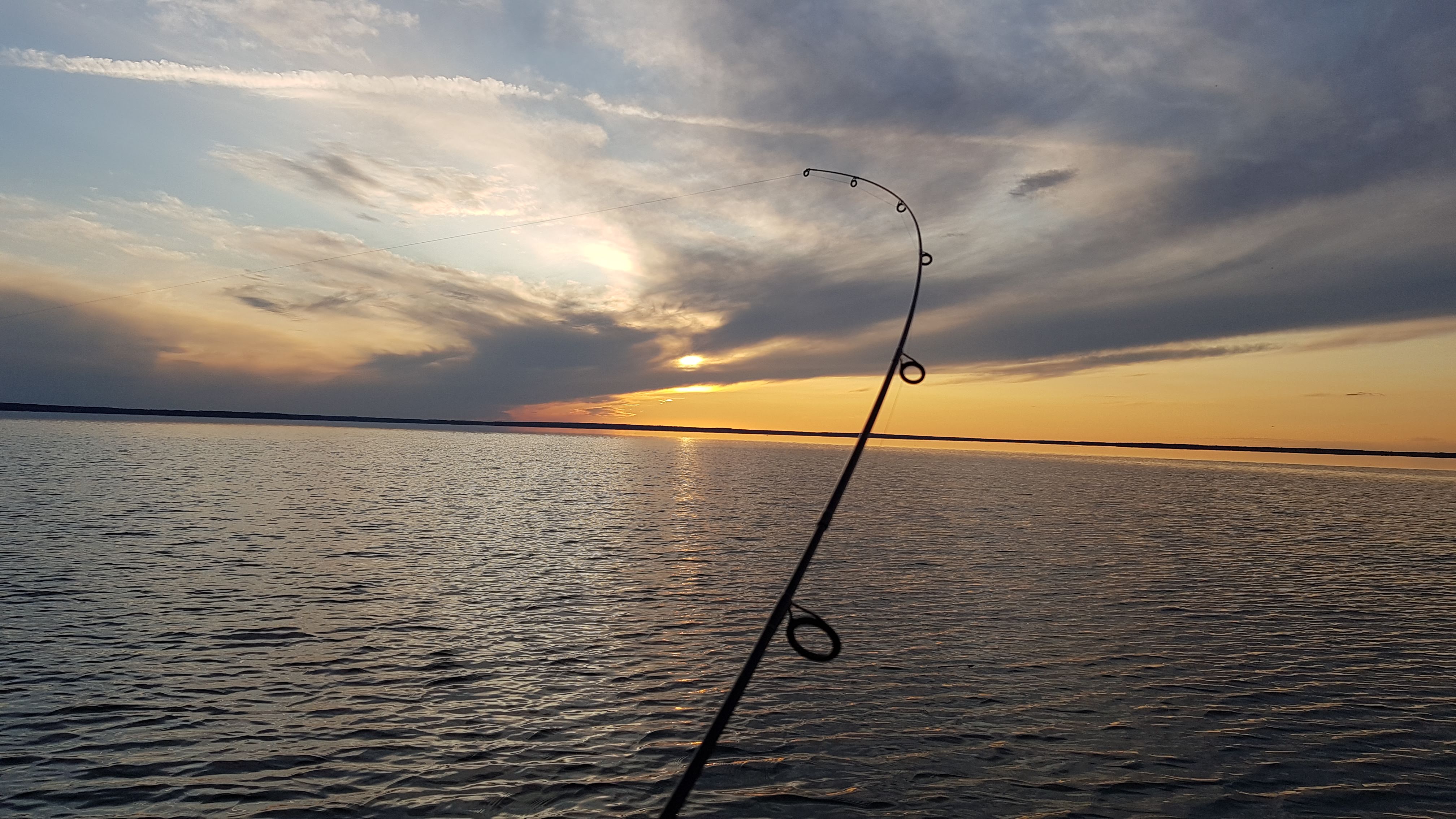 fishing pole being cast in lake